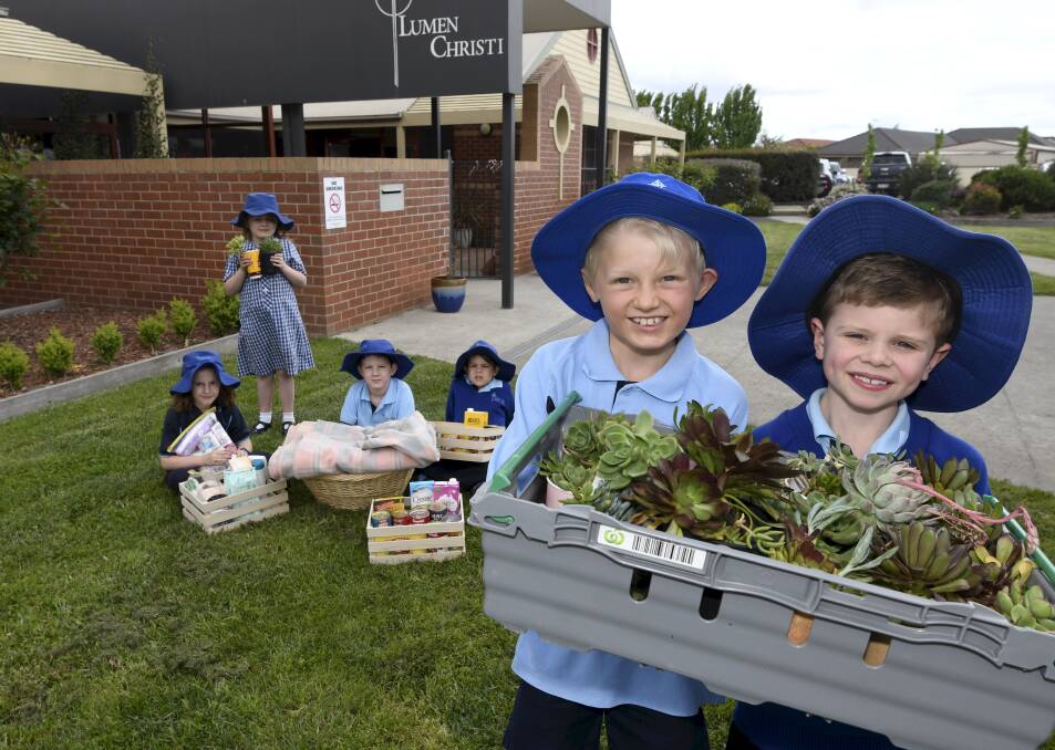 AID: Lumen Christi pupils Emily, Hayley, Reese, Hunter, Liam, Cohen with the food collected for Soup Bus, care packages for Shower Bus and plants for sale to raise money to buy Back Pack Beds for the homeless. Picture: Lachlan Bence