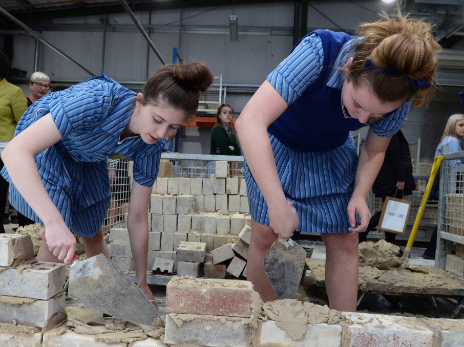 TRADE SKILLS: Loreto College students Victoria Cooper and Grace Mader tackle the trowels as they try bricklaying at Fed Uni's Try a Trade session, which gave 200 girls that chance to learn new skills. Picture: Kate Healy