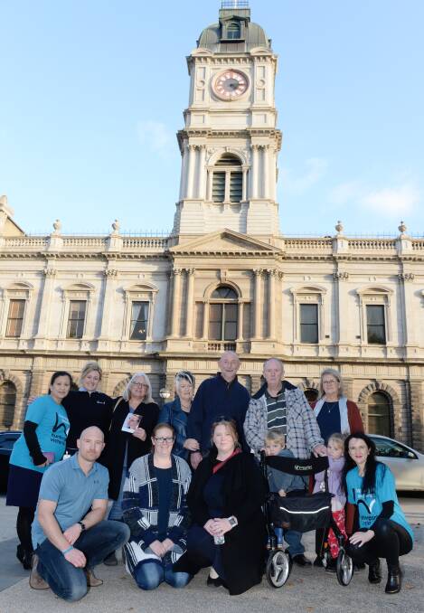 BLUE: Bernard and Tim Collins (centre) with their families, supporters and Huntington's Victoria staff. Picture: Kate Healy