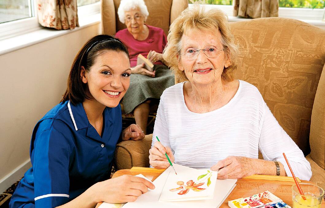 An aged care worker helping a dementia patient with activities.