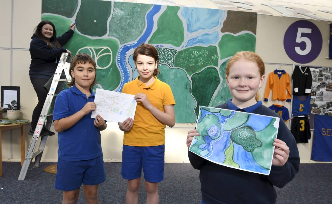 Eliza McIntosh and Sebastopol Primary pupils Kate, Brock and Nell with some of the displays for the school's 150th anniversary next week. Picture by Lachlan Bence