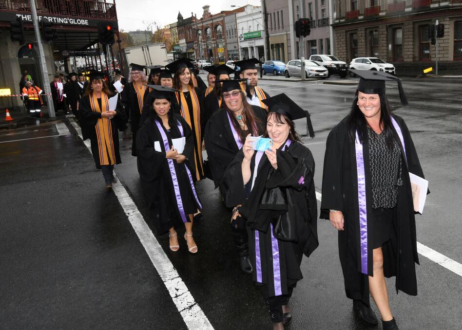 CROSSING: Federation University Arts Academy and TAFE graduates make their way across Lydiard Street. Picture: Lachlan Bence