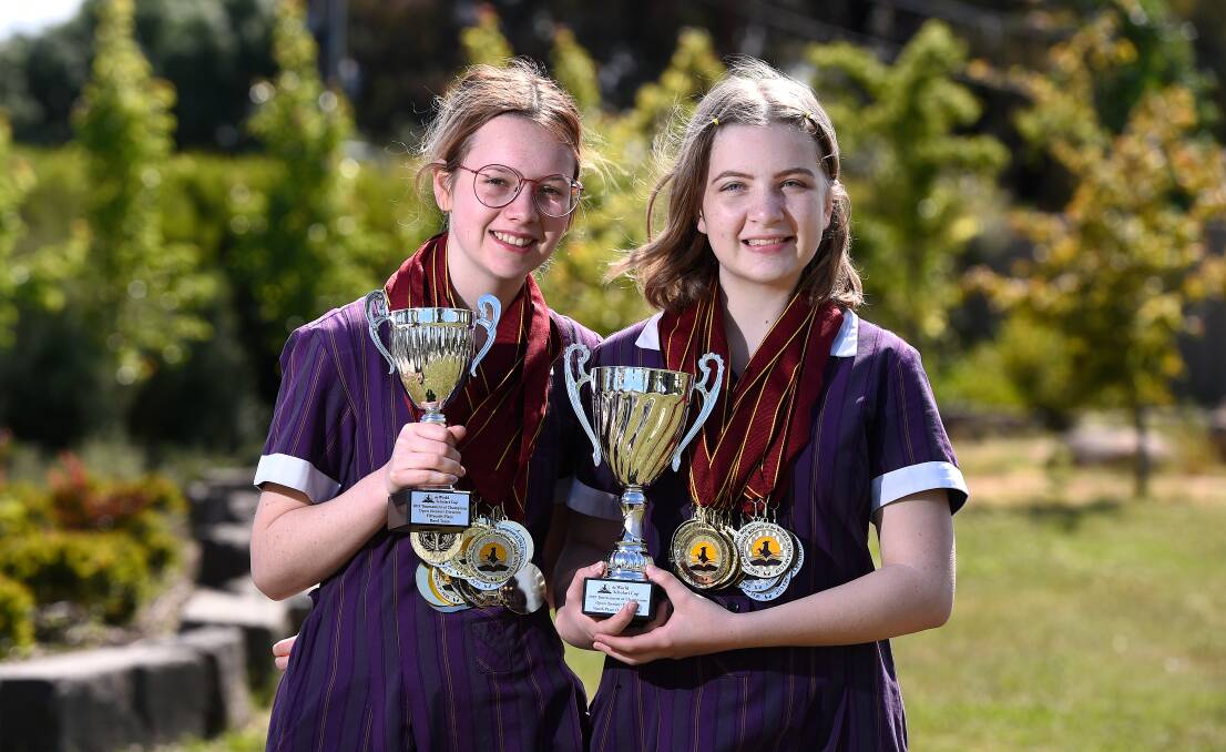 WINNERS: Bethany Somers and Abi Merry from Phoenix P-12 with the trophies and medals they won at the World Scholars Cup Tournament of Champions at Yale University in the US earlier this month. Picture: Adam Trafford