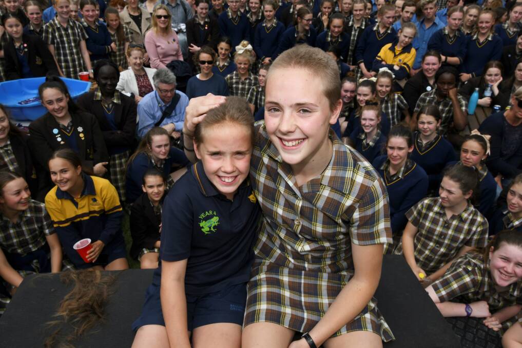 AFTER: Surrounded by classmates, teachers and family the girls show off their new cropped hairdos after taking part in the Leukemia Foundation's World Greatest Shave. Picture: Lachlan Bence