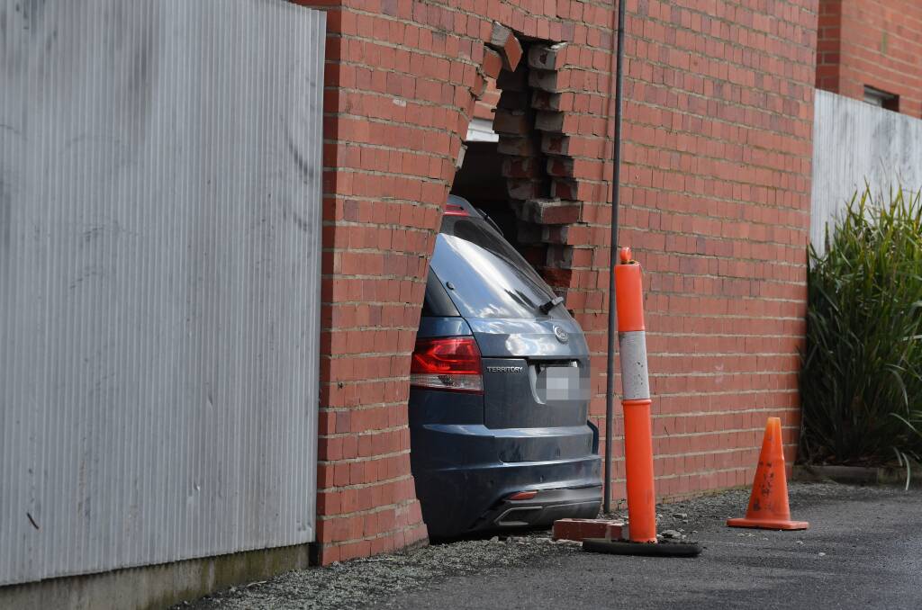 REAR: Only the rear of the car was left outside after a women crashed her car through the wall of St Andrews Hall. Picture: Lachlan Bence