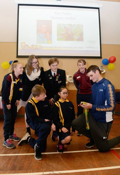 LEADERS: Archer Alec Potts shows his Olympic bronze medal to school leaders (back) Bridie, Morgan, Peter, and Connor and (front) Kaleb , Myiesha. Picture: Kate Healy 