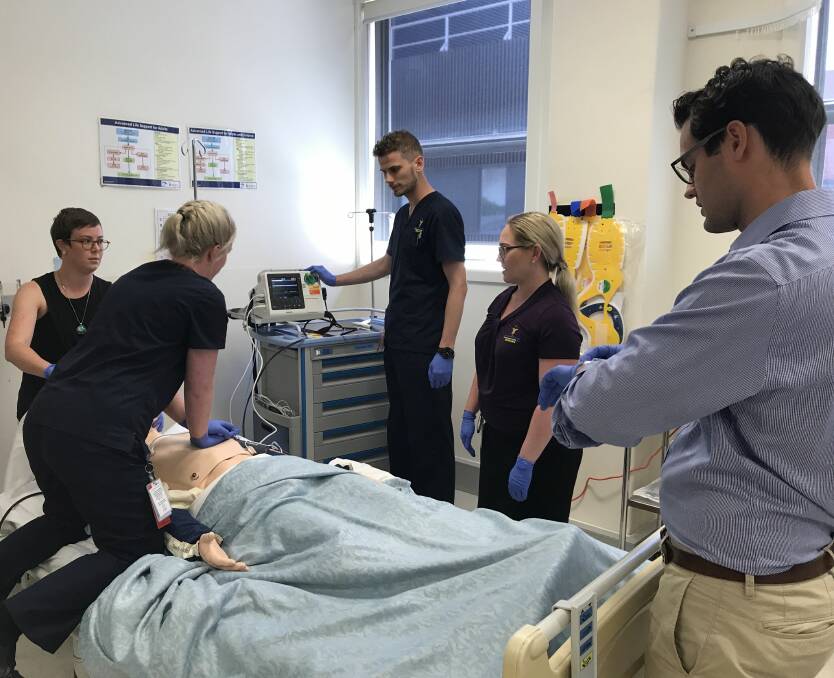 ORIENTATION: Nursing graduates and medical interns work together on a simulator patient during their orientation exercises, under the watchful eye of clinical nursing educator Melissa White (second from right). Picture: Michelle Smith