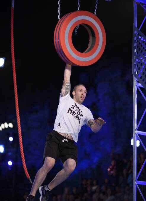 HANGING ON: Clunes circus performer and puppeteer Neal Holmes tackles the tyre swing on his way through the challenging course in the semi-finals of Australian Ninja Warrior.