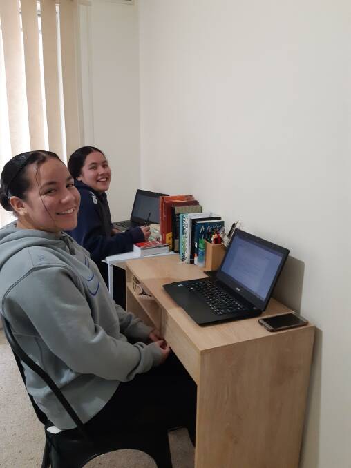 WORK TIME: Atelaite and Lieszel at their new desks. Picture: supplied