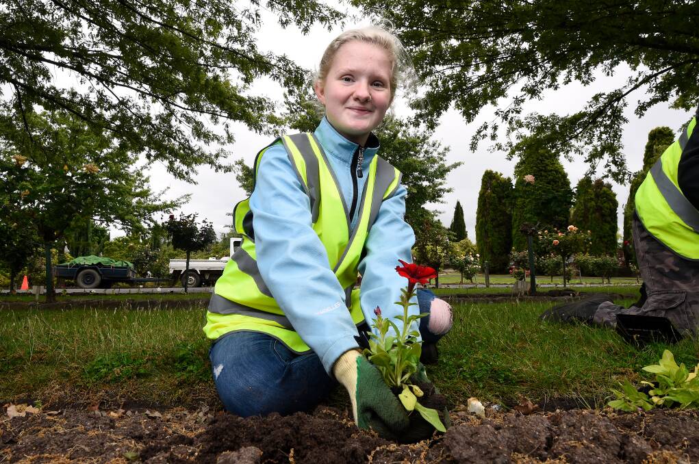 GARDENER: Ballarat Specialist School student Rachael helps plant the petunias the school has grown as part of a partnership with Ballarat General Cemeteries. Picture: Adam Trafford.
