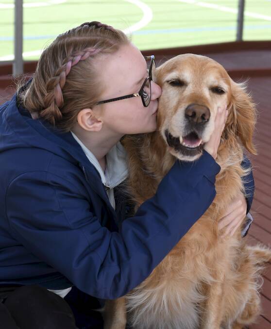 BEST THERAPY: Gemma gives Berry Street therapy dog Phoebe a kiss. Picture: Lachlan Bence