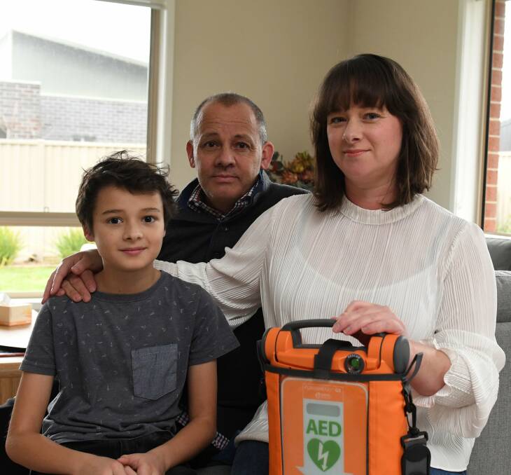 LIFESAVER: Lewis, Stephanie and Neil Wilson with the defibrillator they used to save Lewis after he suffered a cardiac arrest. 