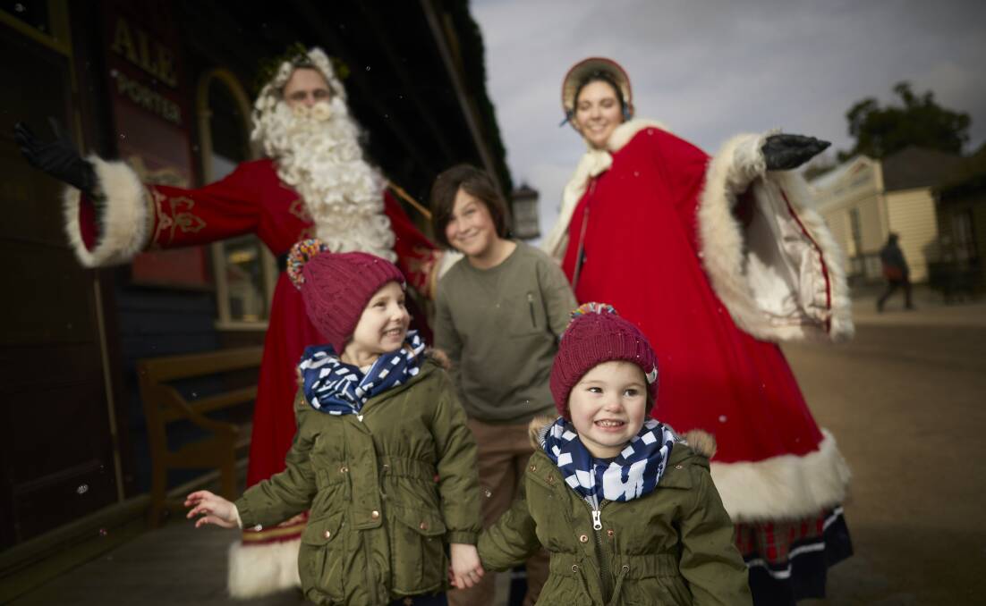 WINTER WONDER: Milla, 4, and Arlie Romein, 2, and Tate Read, 9, have a mid-year audience with Saint Nicholas and his helper at Sovereign Hill. Picture: Luka Kauzlaric