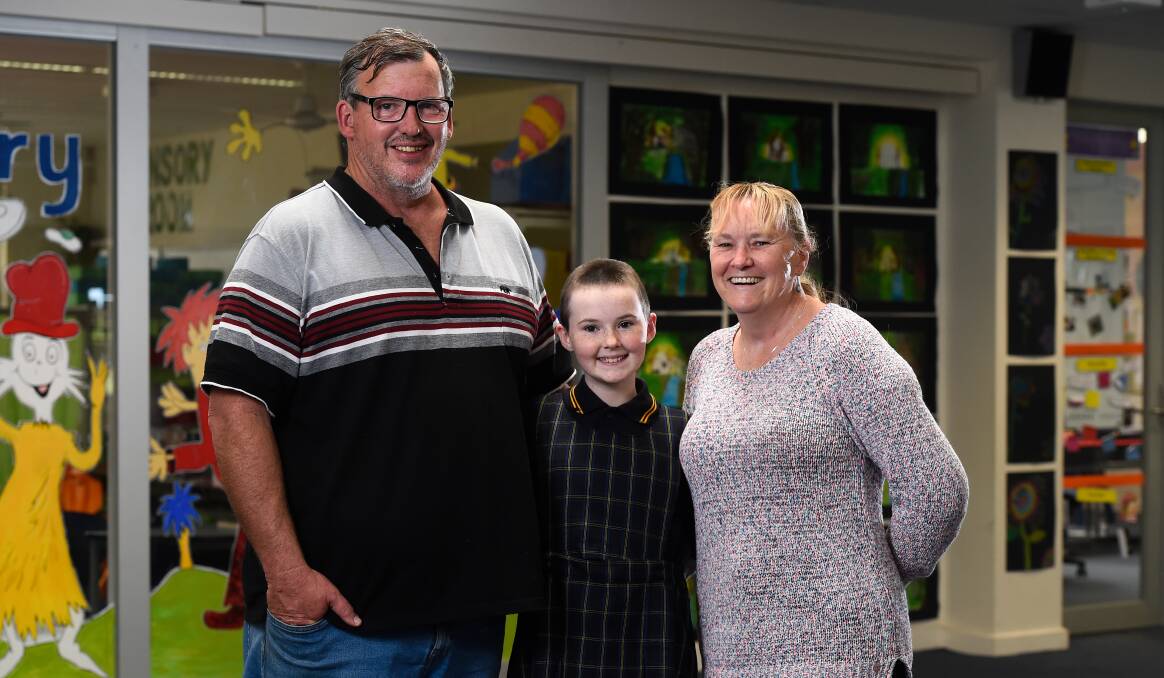 Abbie with her proud parents Ben and Kylie after her Shave for a Cure at Woady Yaloak Primary School's Snake Valley campus. Picture by Adam Trafford
