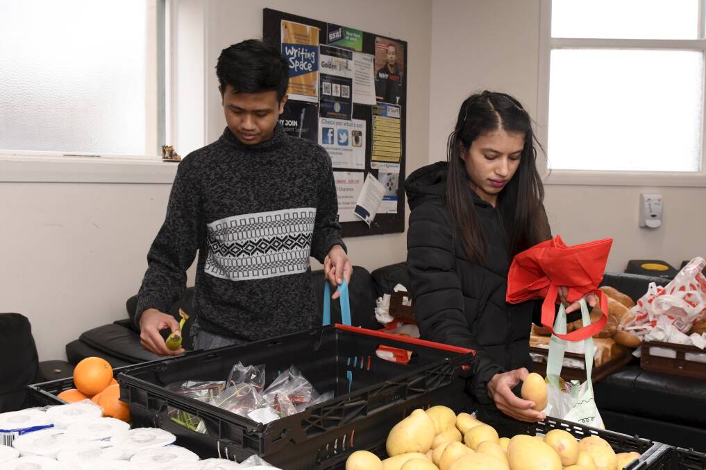 SHOPPING: International students Falih Febrinanto and Puja Dahal get supplies from the community pantry run by Federation University, Australian Catholic University and City of Ballarat. Picture: Lachlan Bence
