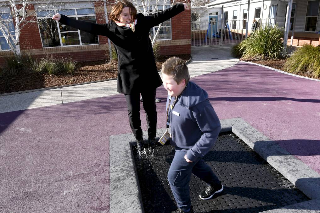 JUMP: Juliana Addison and student leader Jeremy have some fun on the in-ground trampoline. Picture: Lachlan Bence