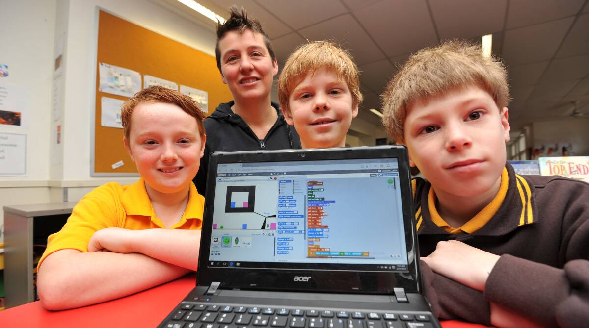 CODERS: Bailey, 11, Code Club educator Emma Bennett, Elliot, 9, and Seth,10, joined more than 10,000 children to break a world record for the greatest number of children coding at once. Picture: Lachlan Bence.