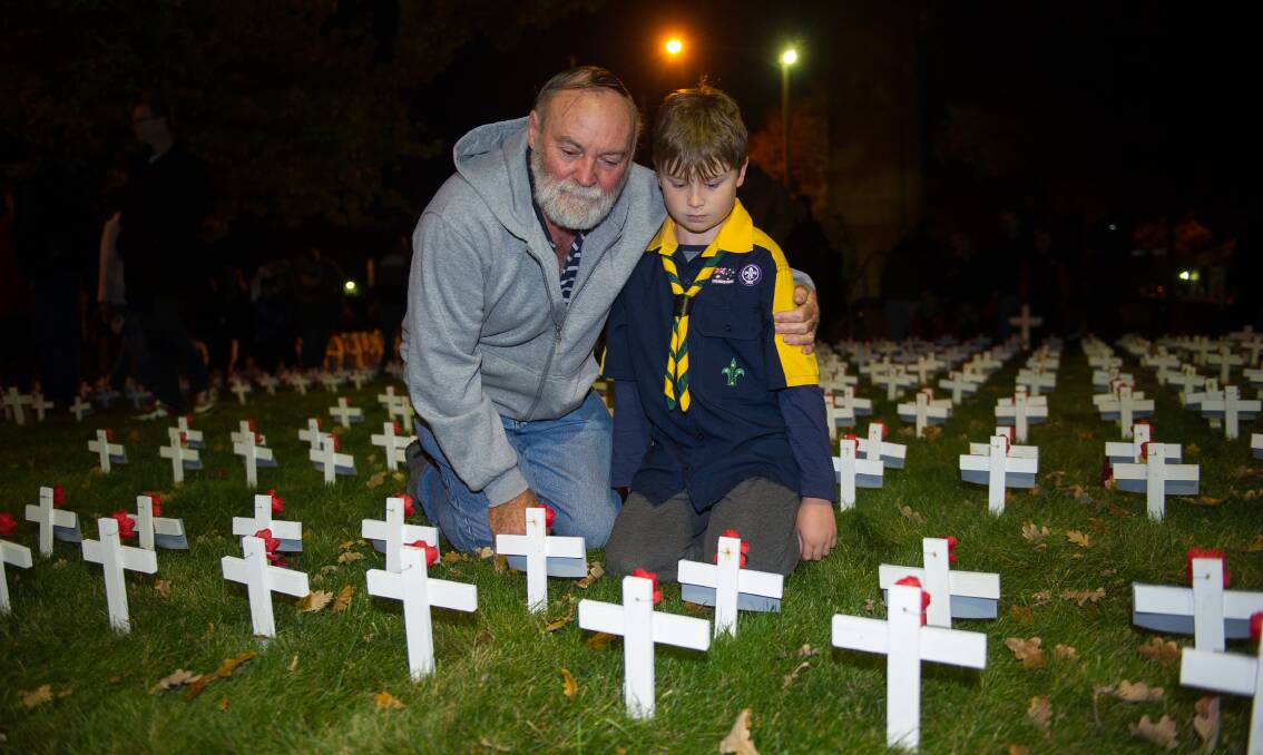 PAY TRIBUTE: Chris Lethbridge and Cameron Philp, 9, take a moment to commemorate their ancestor  Francis Ernest D'Albedyhll Lethbridge who served during WWII. Picture: Dylan Burns.