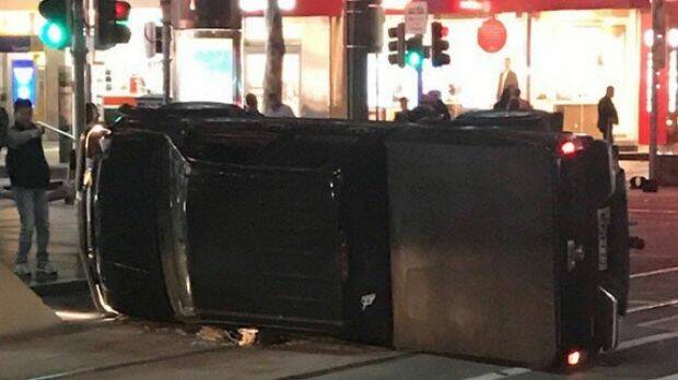 The car flipped onto its side on Bourke Street.  Photo: Twitter/@andrewself.