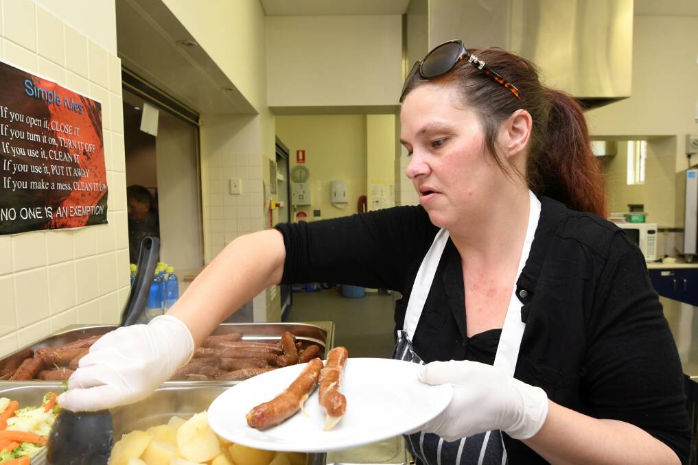 FOOD'S UP: Salvation Army volunteer Jessie Kelly serves a meal for visitors to the meals program on Tuesday. Picture: Lachlan Bence 