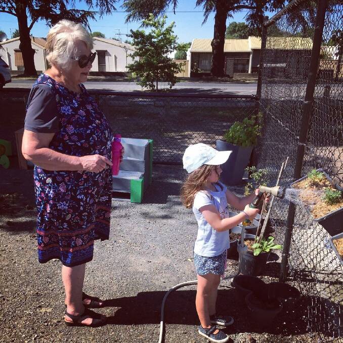 Carol and four-year-old Ella watering the Food is Free garden. 