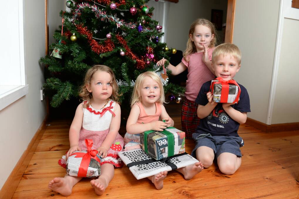 REDUCE: Eliza Jane Elliott, 2, Cassandra Molloy, 2, Maxwell Molloy, 5, and Annabella Elliott, 5 open presents wrapped with newspaper. Picture: Kate Healy 