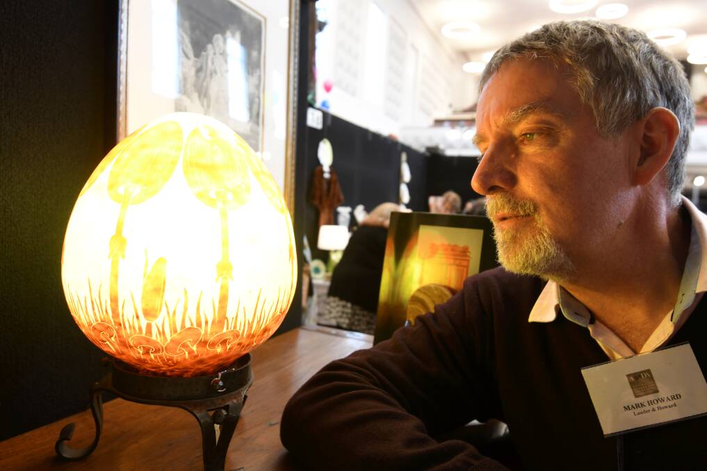 TREASURE HUNTER: Antique dealer Mark Howard admires a gem of a piece at the Ballarat Antique Fair at Civic Hall on Saturday. Pictures: Lachlan Bence 