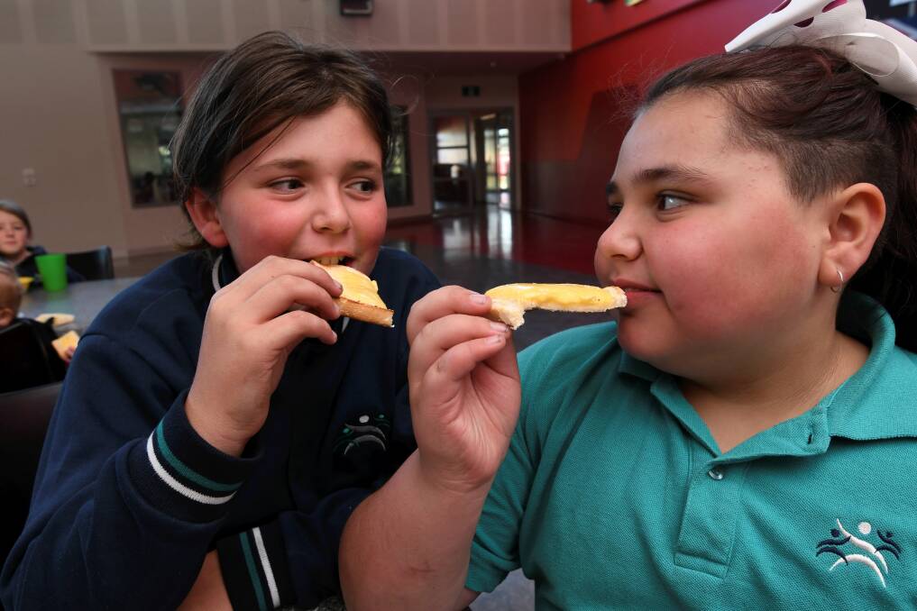 BREAKFAST TIME: Siblings Blair and Tasha enjoy cheese on toast at the Yuille Park Community College breakfast program. Picture: Lachlan Bence 