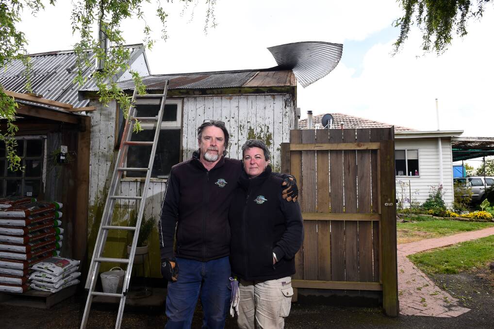 SURVIVORS: Navigators Nursery owners Neville Quick and Lisa Seville were cleaning up damage from the storm on Friday, including metal ripped from the shop roof. Picture: Adam Trafford 
