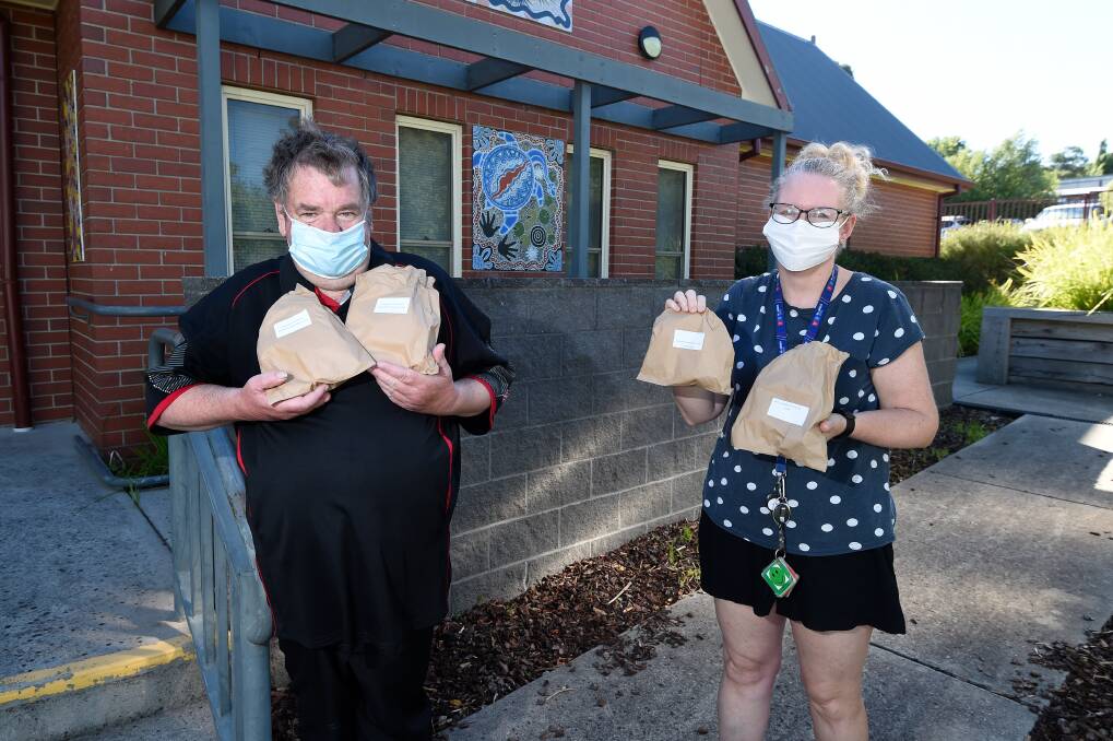 LUNCH: Salvation Army volunteer Gavin Maguire delivers lunch packs to Mount Pleasant Primary School education support staff Sarah Cahill. Picture: Adam Trafford 