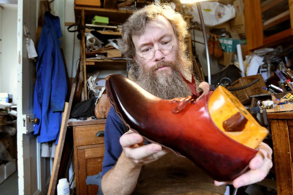 OLD WAYS: Clunes bootmaker Duncan McHarg examines a current order. He has been working on the pair with a four figure price tag for two and a half years. Pictures: Lachlan Bence 
