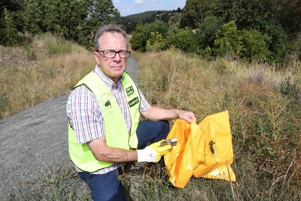 LITTER: Redan resident Col Palmer picks up litter at the river for Clean Up Australia Day. Picture: Lachlan Bence 