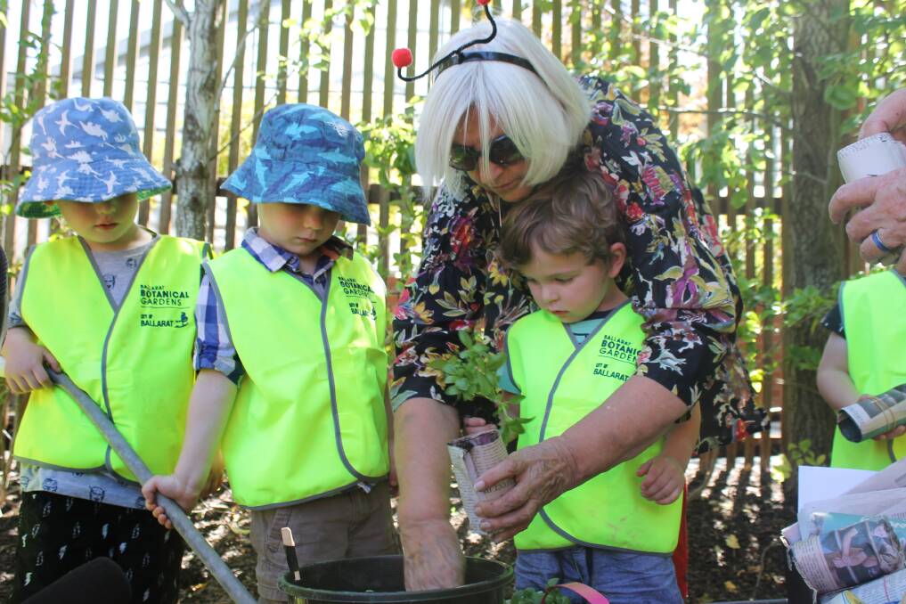 Julie Bradby, Friends of the Botanical Gardens life member and BotaniKIDS coordinator helps William Smith, 2 plant herbs. Picture: Rochelle Kirkham 