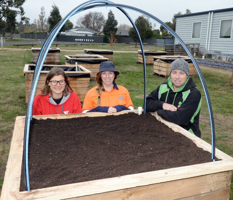 FRESH FOOD: YMCA health promotions officer, Conservation Volunteers Australia's Tess Marshall and Dan the Veggie Bin Man install wicker garden beds at the Delacombe Community Garden. Picture: Kate Healy 

