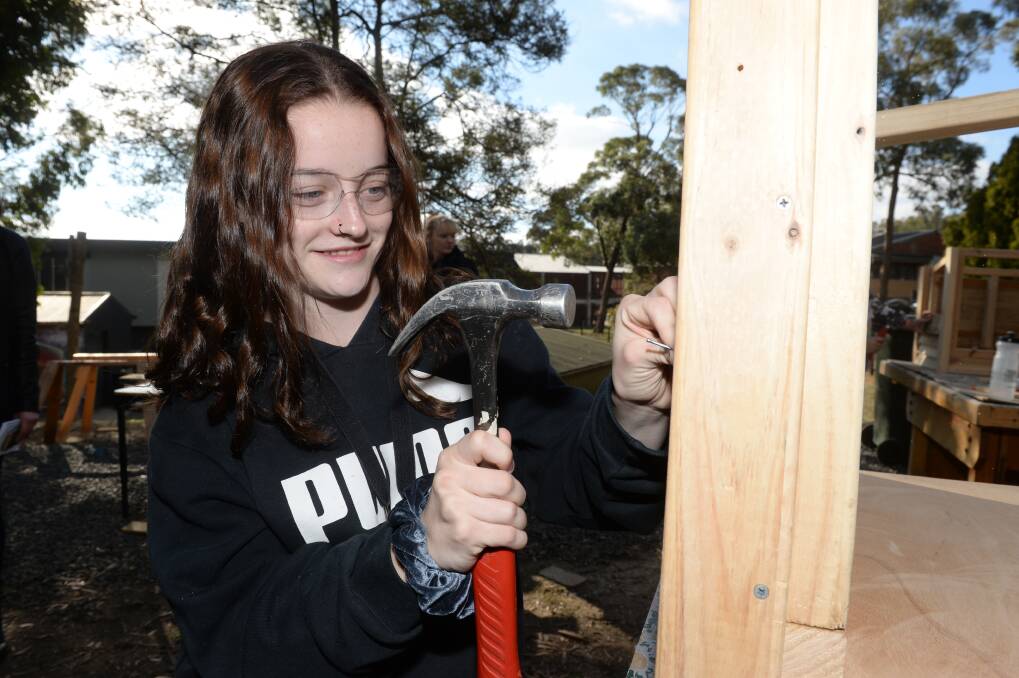 CONFIDENCE: Mount Clear College year nine student Sarah is hammering nails into wood to make a dog kennel as part of the Hands on Learning program. Picture: Kate Healy 