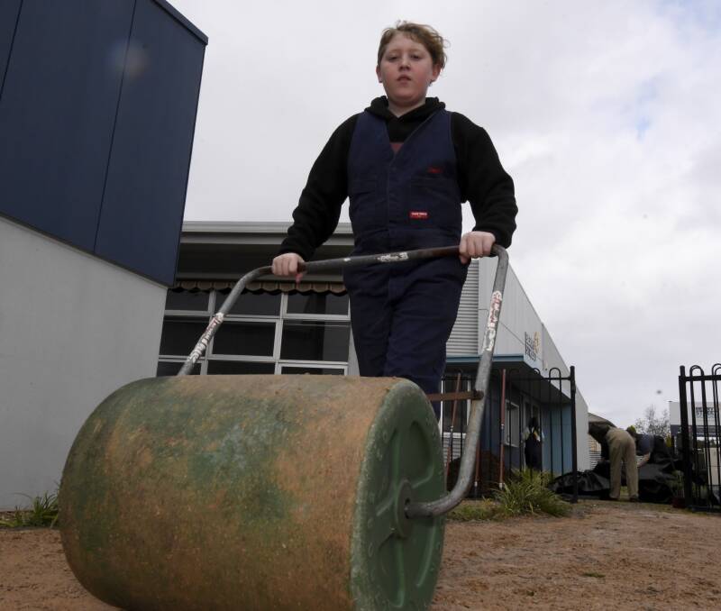 PURPOSE: Berry Street School student Connor flattens a new path at the school. 