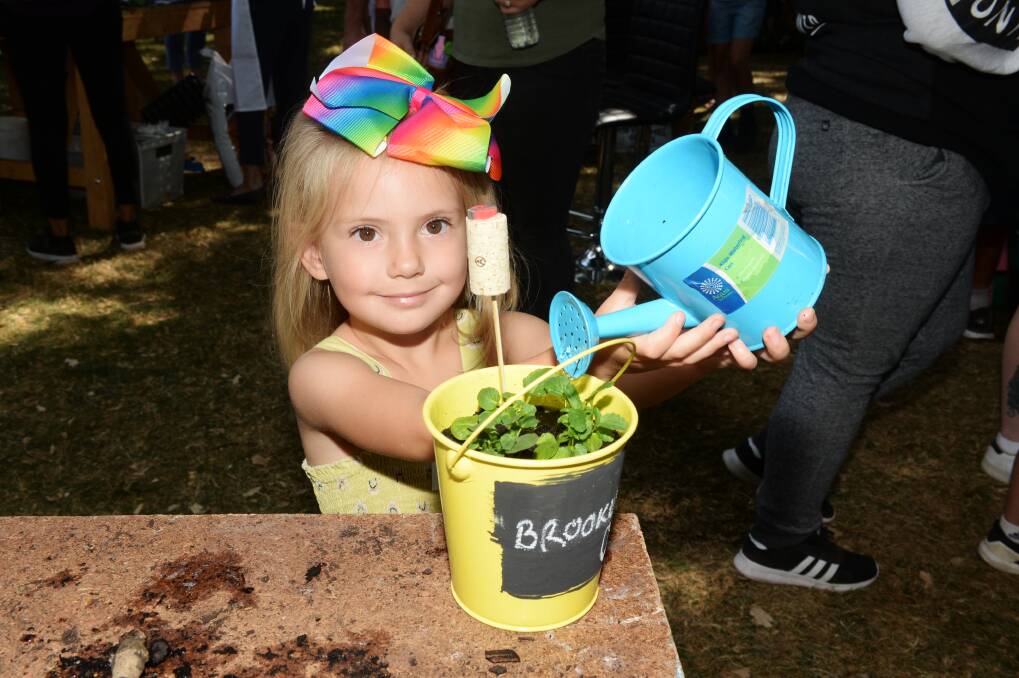 GREEN THUMB: Brooklyn Kidney, 4, from Melton waters her knew plant she potted with the help of BotaniKIDS volunteers at the Ballarat Botanical Gardens on Saturday. Picture: Kate Healy 