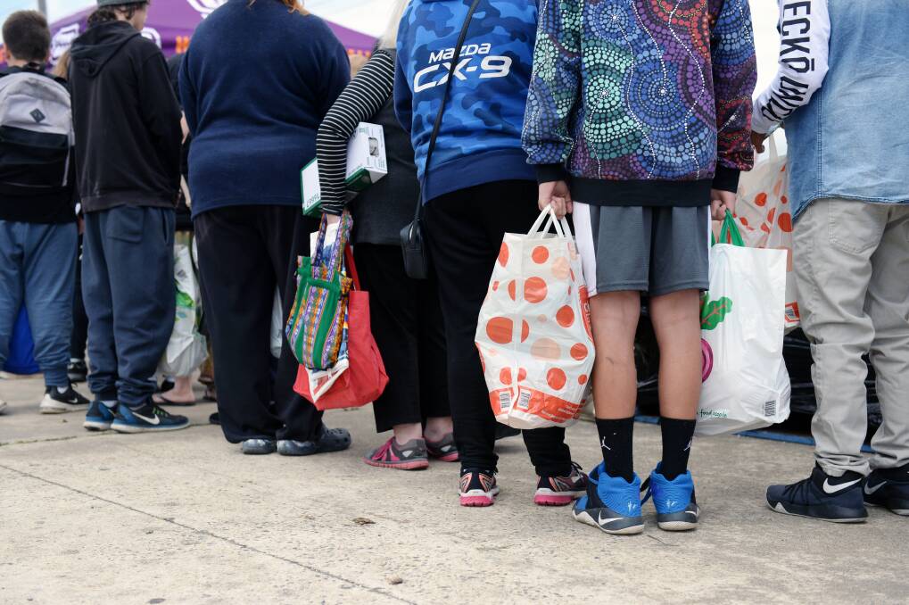 The faces of hunger: hundreds of families queue for food relief