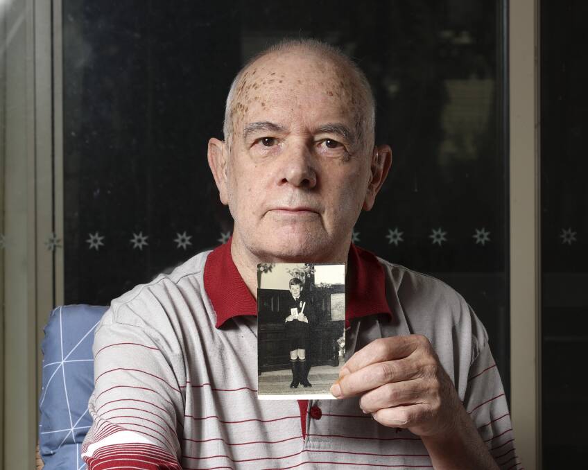 Martin Mennen holds a photo of himself as a happy young boy, before the traumatic incident.