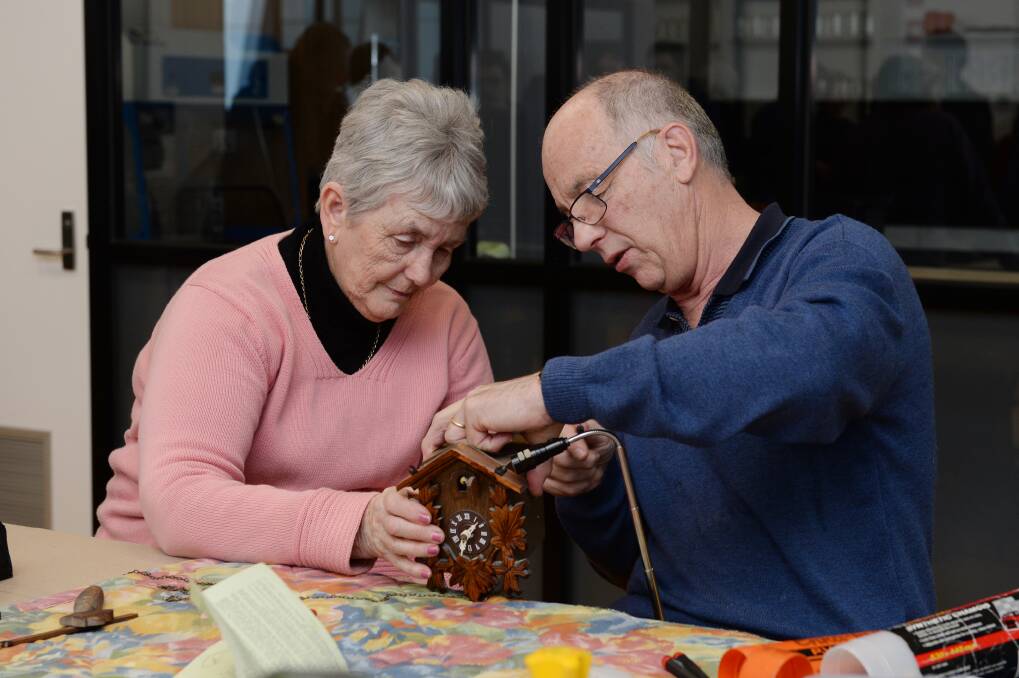 REPAIR: Danny Ellis works on repairing a broken wooden cuckoo clock at the launch of Ballarat's first Repair Cafe. 
