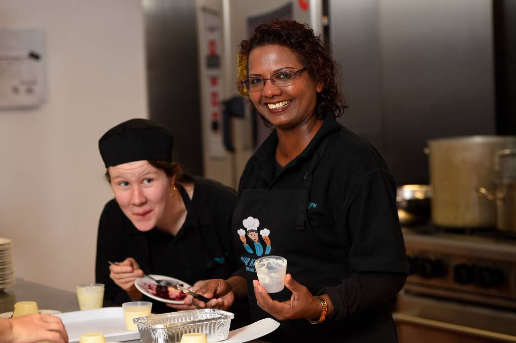 TEAMWORK: Volunteers Zoe Sharpe and Noreen Van Den Hoek help serve dessert during the Ballarat Neighbourhood Centre community lunch as part of the Our Kitchen Cooking Up Jobs program. Picture: Adam Trafford 