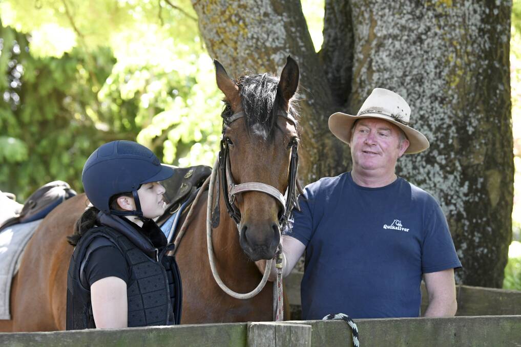 BACK IN THE SADDLE: 15-year-old Jorja Mentis prepares for a trail ride with Hepburn Lagoon Trail Rides owner Kieran Prendergast. Pictures: Lachlan Bence 