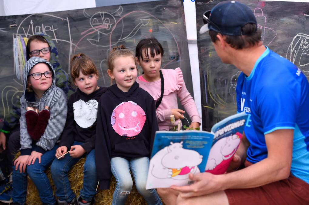 ENGAGED: Ballarat Foundation CEO Matt Jenkins reads to children Corben Boehm, 9 Isabella Freckleton, 6, Rosalie Freckleton, 5, Charlotte Freckleton, 8 and Lexi Boehm, 7 as part of the Imagination Library during the Begonia Festival. Pictures: Adam Trafford 