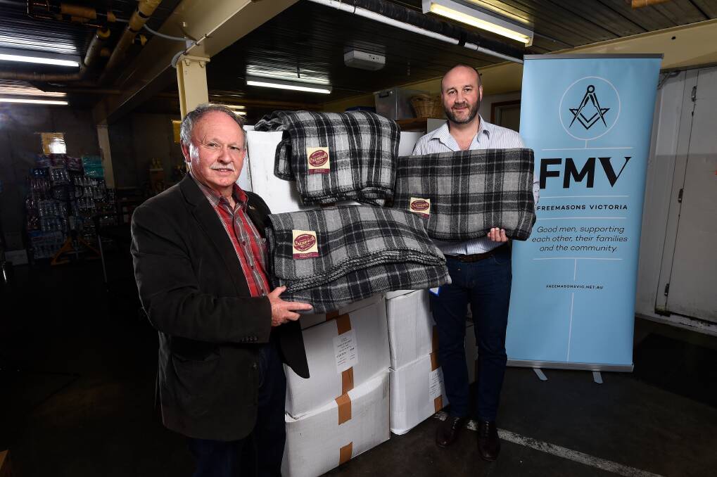 DONATION: Freemasons Victoria Sturt-Buninyong Secretary Ron Fleming hands over blankets to Uniting Ballarat acting senior manager housing and homelessness Warrick Davison. Picture: Adam Trafford 