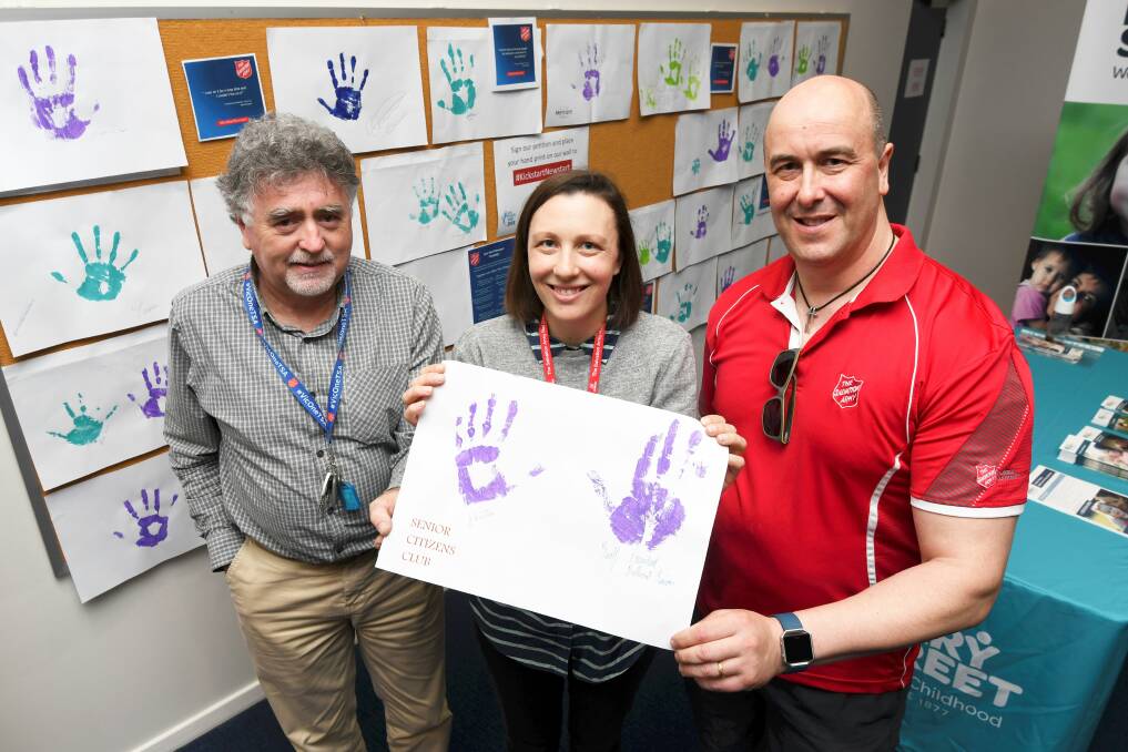 CAMPAIGN: Handprints and signatures for Newstart petition with Salvation Army workers John Clonan, Charlie Sam, Andrew Van Gaalen. Picture: Lachlan Bence 