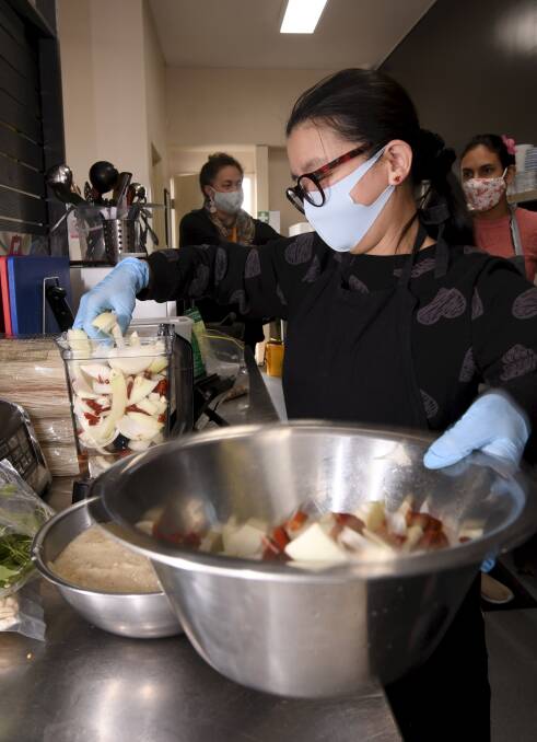 TEAMWORK: Cook Joy Milligan helps prepare food.