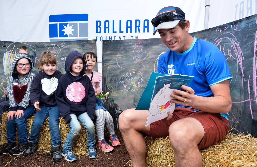 ENGAGED: Ballarat Foundation CEO Matt Jenkins reads to children Corben Boehm, 9 Isabella Freckleton, 6, Rosalie Freckleton, 5, Charlotte Freckleton, 8 and Lexi Boehm, 7 as part of the Imagination Library during the Begonia Festival. Picture: Adam Trafford