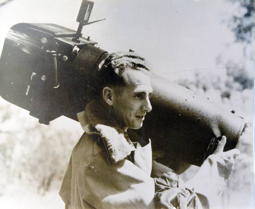 Mr Harvey's father holding the camera he used to take aerial photos during the war. 
