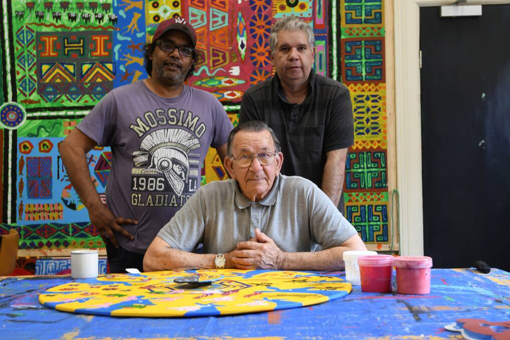COLLECTIVE: Pitcha Makin Fellas artists Peter-Shane Rotumah, Ted Laxton and Adrian Rigney work on an Aboriginal Clock in their studio. Picture: Lachlan Bence 