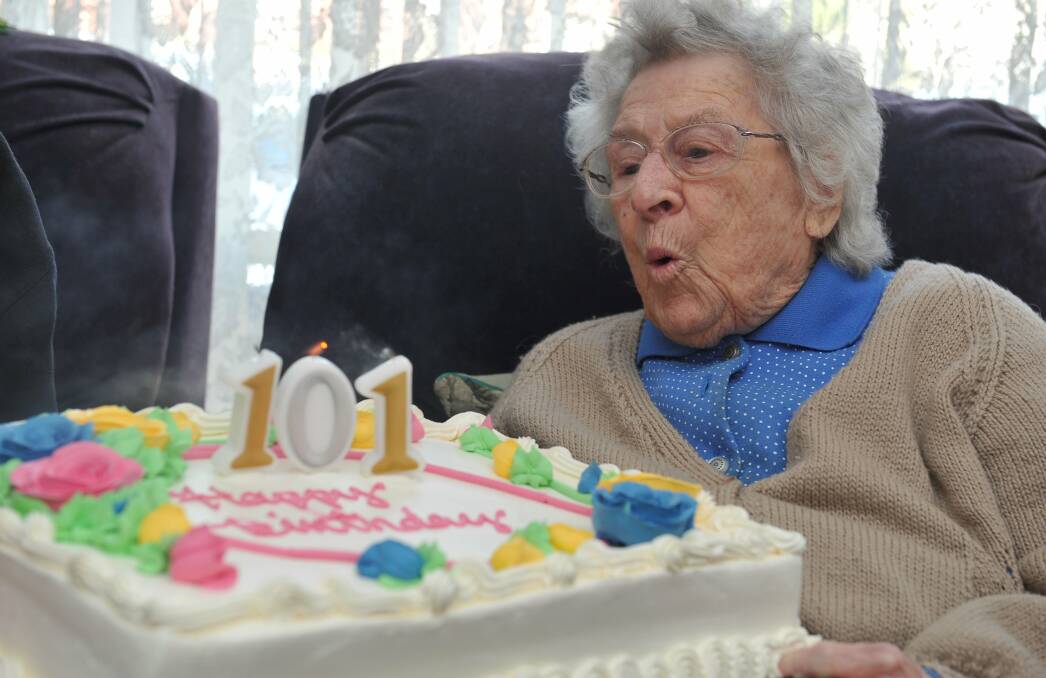 Frances Harris blowing out the candles on her 101st birthday cake. Photo: Lachlan Bence.